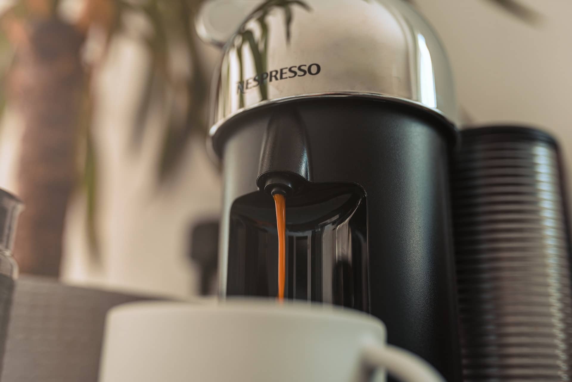 nespresso machine pouring into coffee cup