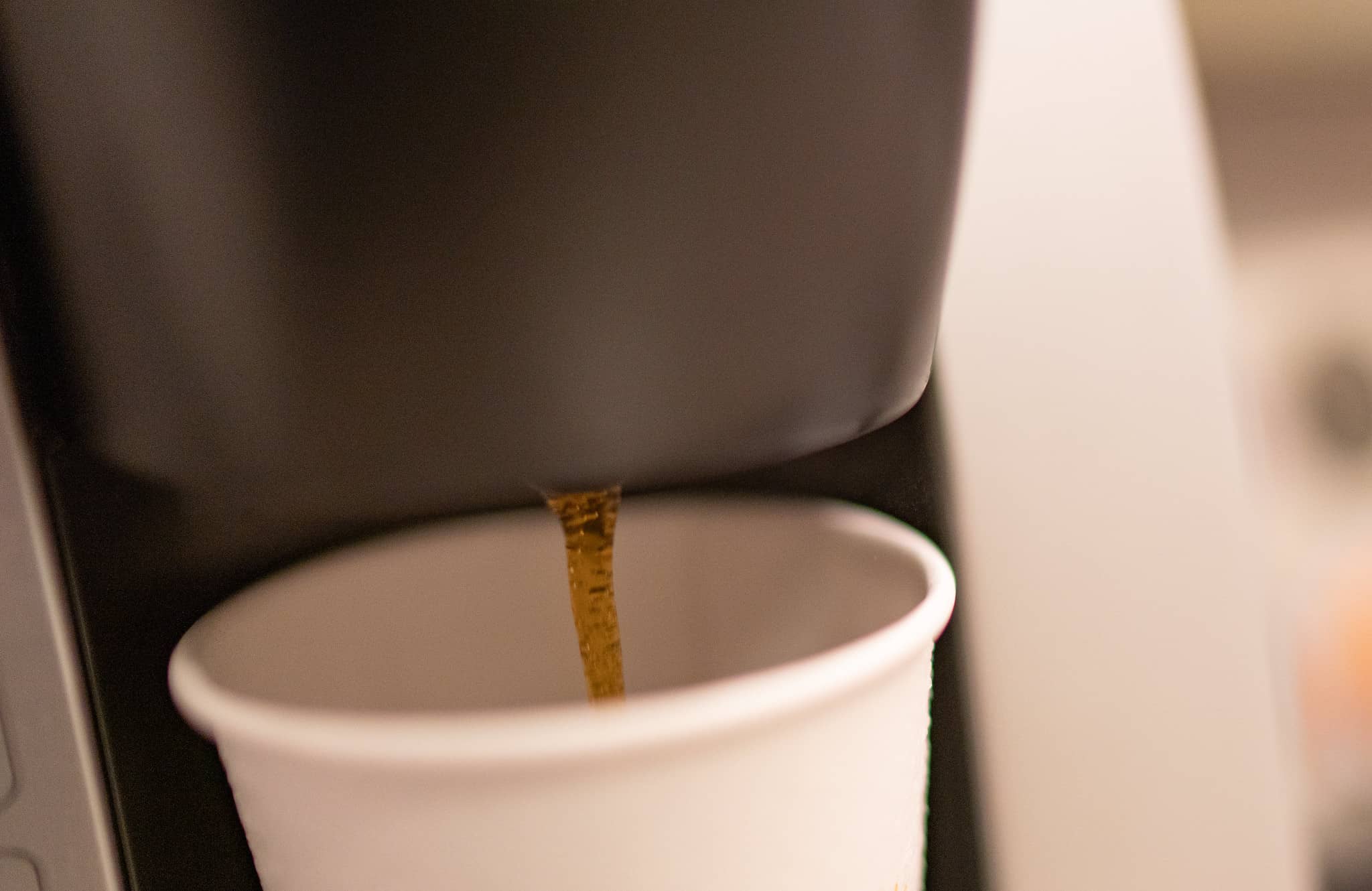 keurig pouring coffee into a paper cup