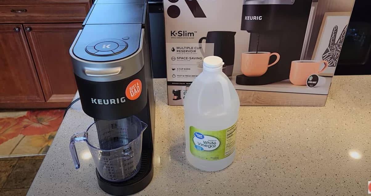 keurig coffee machine next to jug of vinegar
