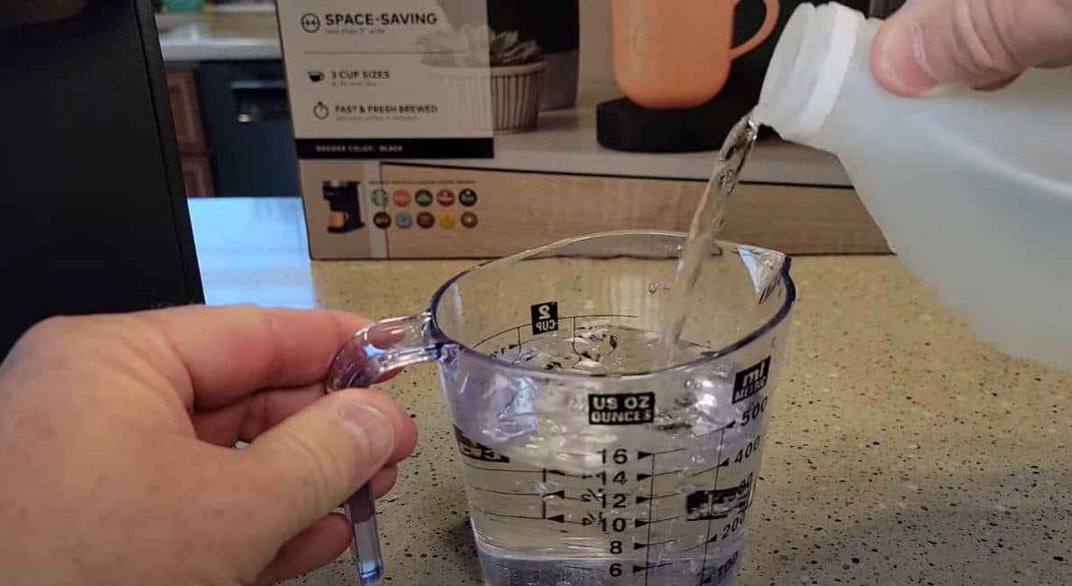 pouring vinegar into measuring cup